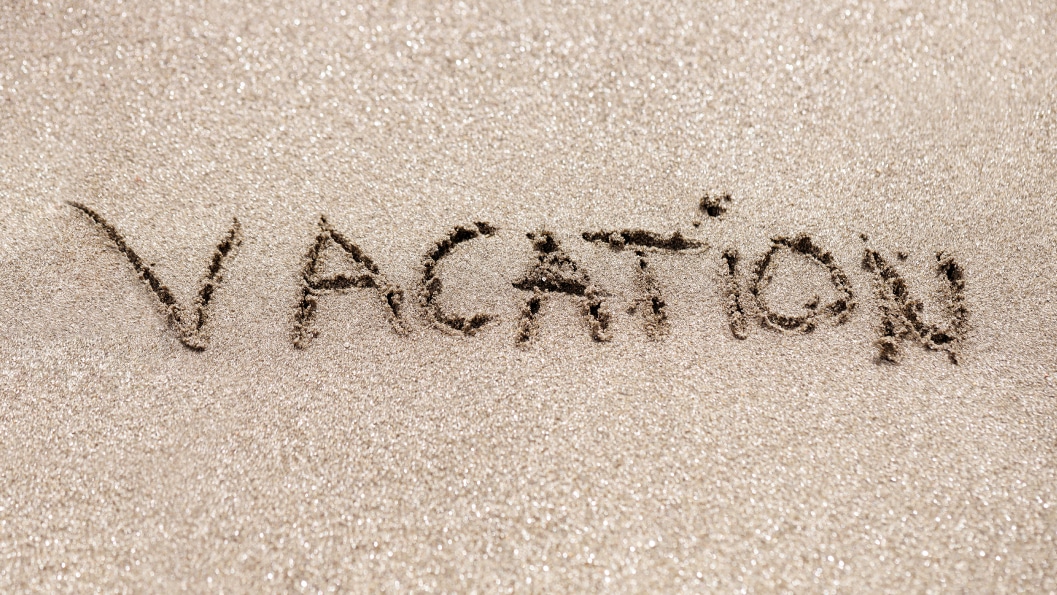 Vacation written in sandy beach